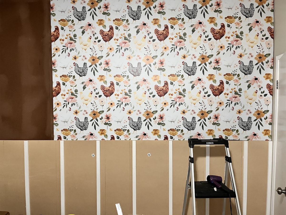 Accent wall with wallpaper above fresh paneling, finish work in progress