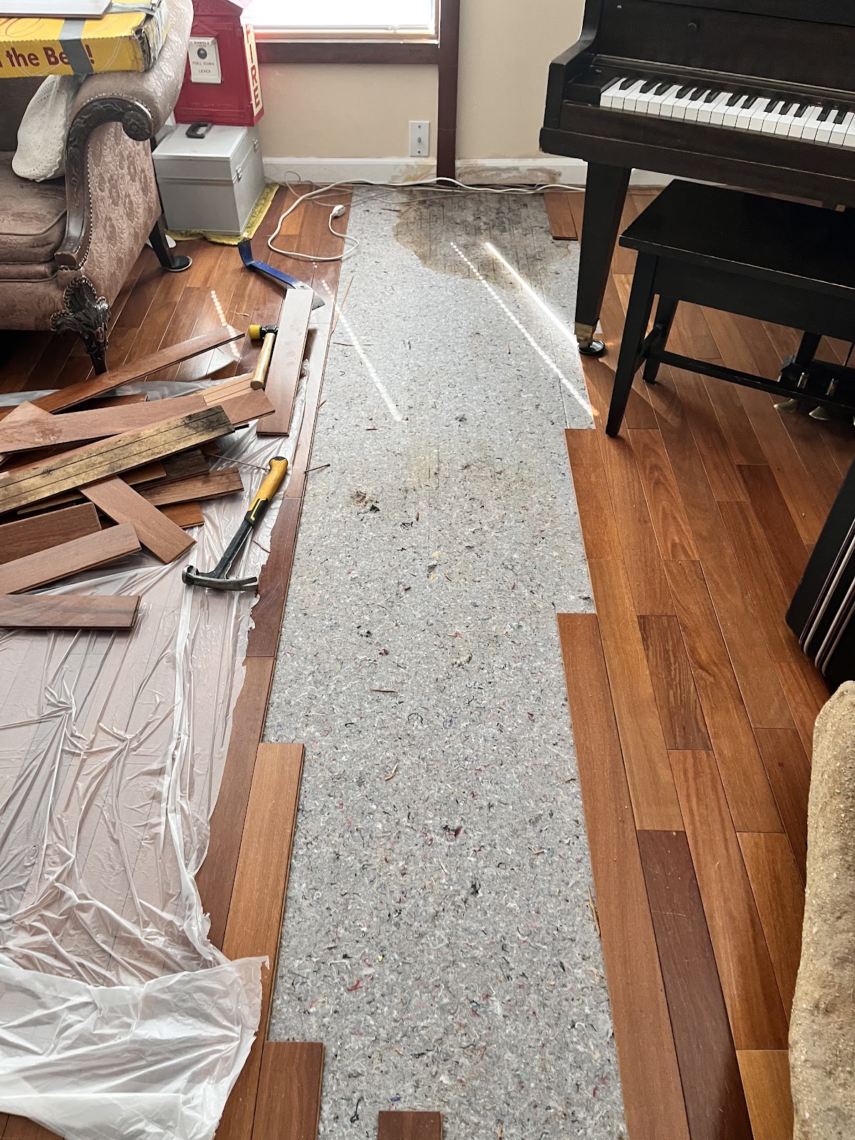 Hardwood floor repair in progress, planks staged and tools at hand